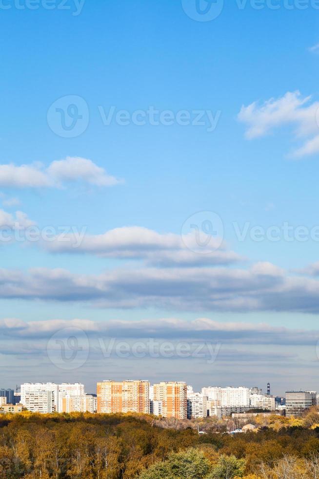 blue sky with clouds over city and woods in autumn photo