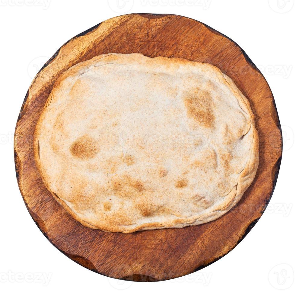 closed flat pie on wooden board isolated photo