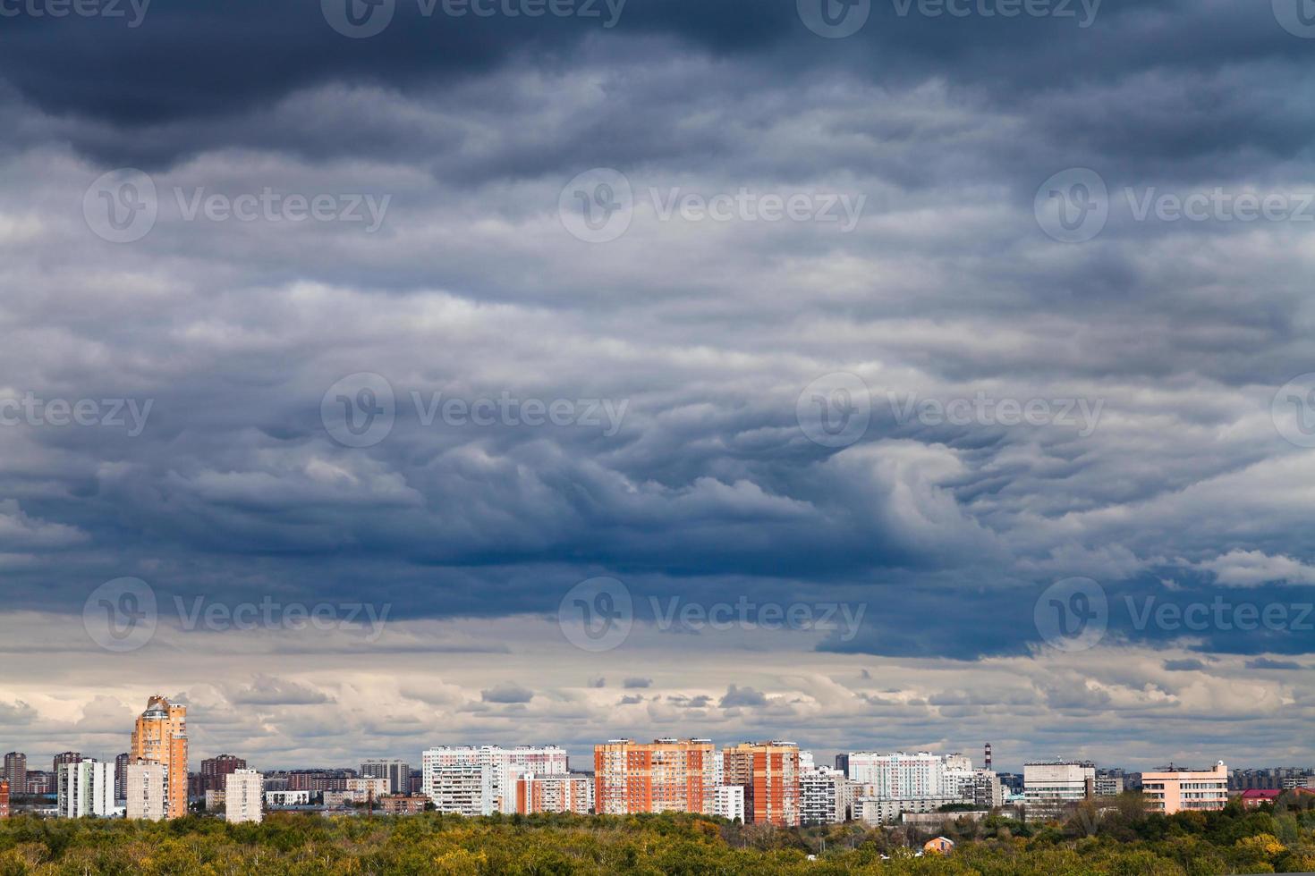 dark blue rainy clouds over city in autumn photo