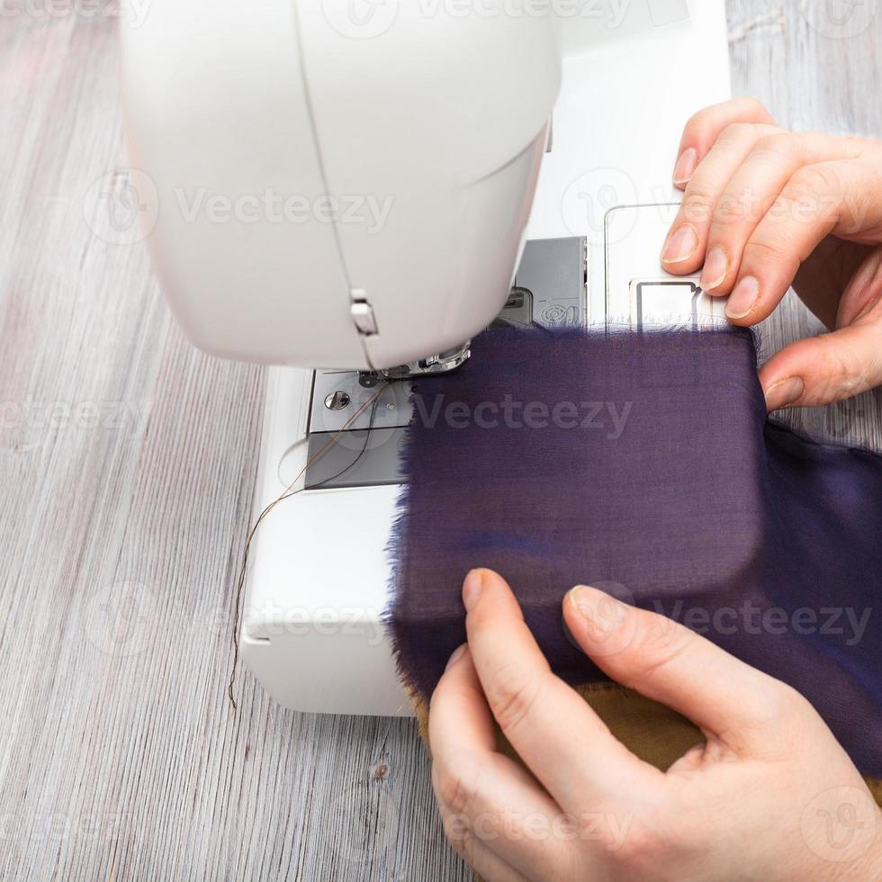 designer sews strips of fabrics for patchwork photo