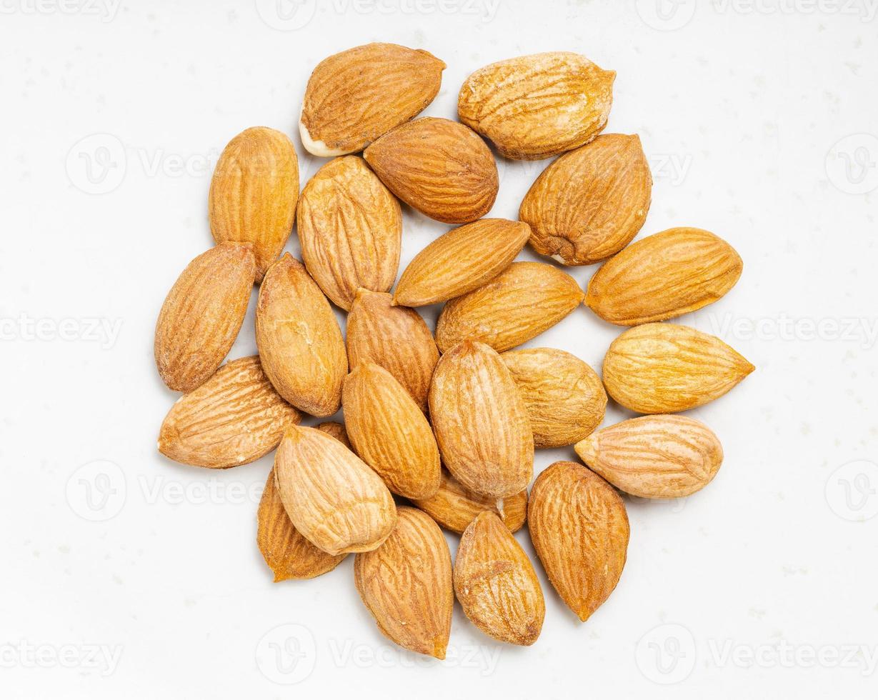 pile of raw apricot kernels close up on gray photo