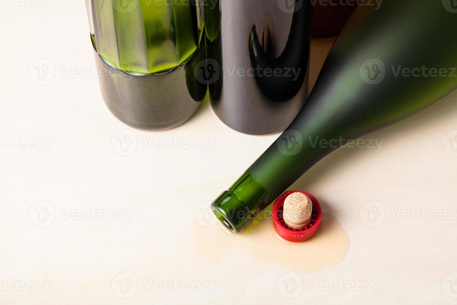 bottle and cork in spilled cognac near bottles photo