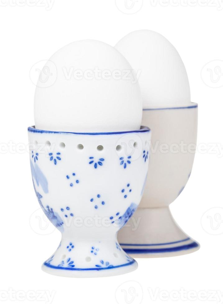 side view of pair of white boiled eggs in egg cups photo