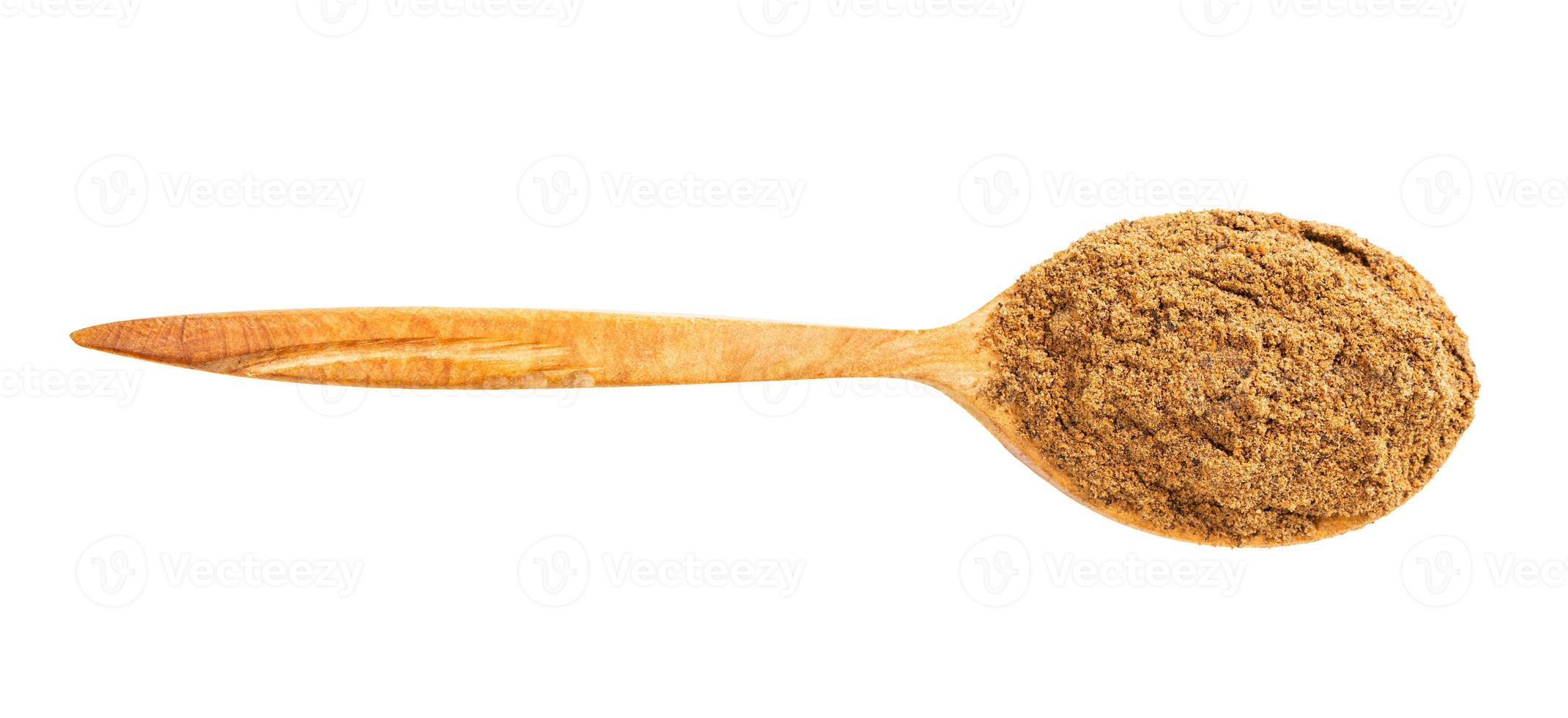 top view of wood spoon with nutmeg powder isolated photo