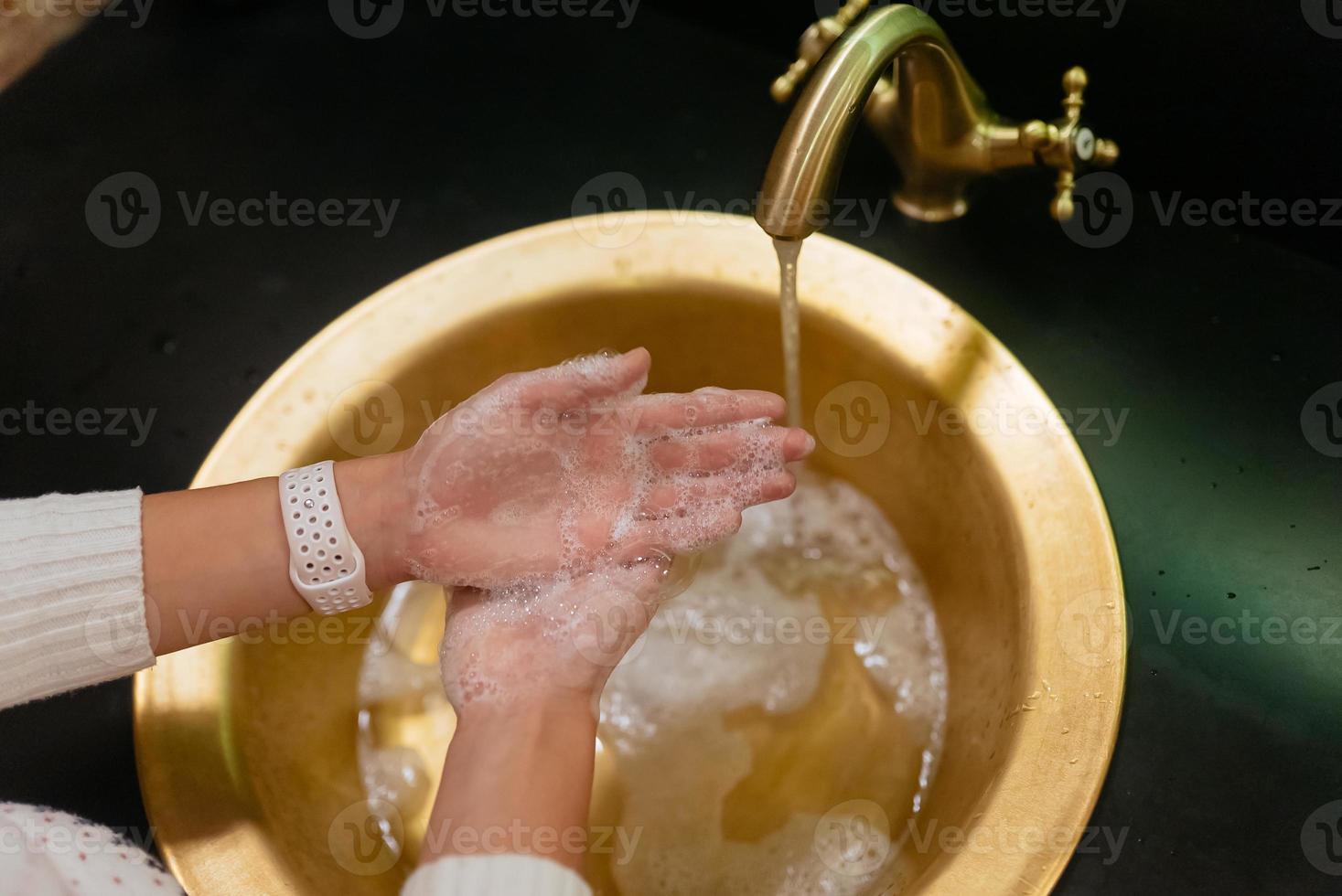 Close up photo of woman washes her hands with soap and water.