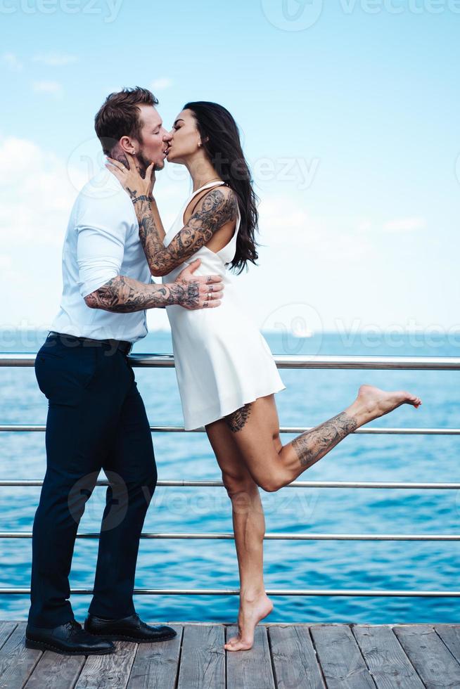 chico y chica en el muelle del mar foto