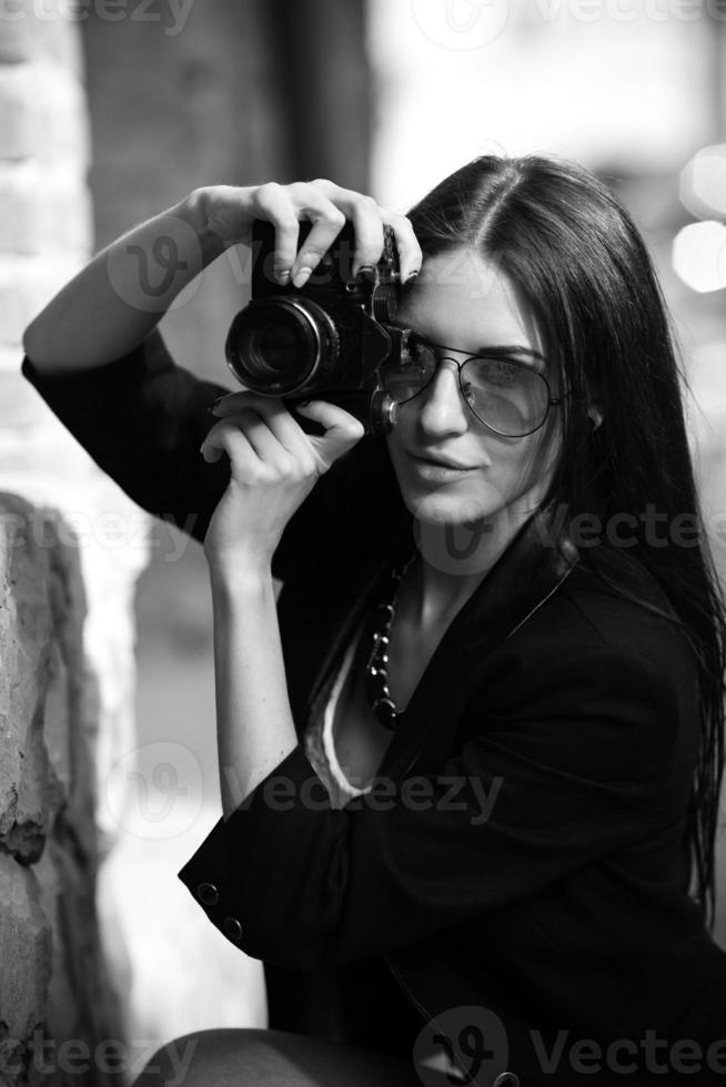 Beautiful female photographer posing with camera photo