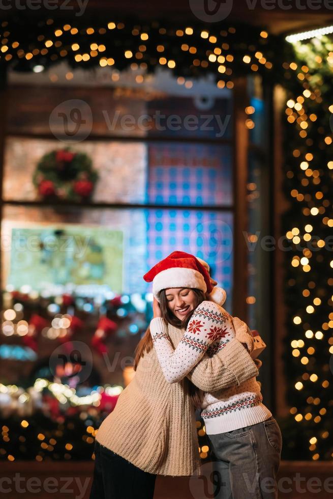 Portrait of happy cute young friends hugging each other photo