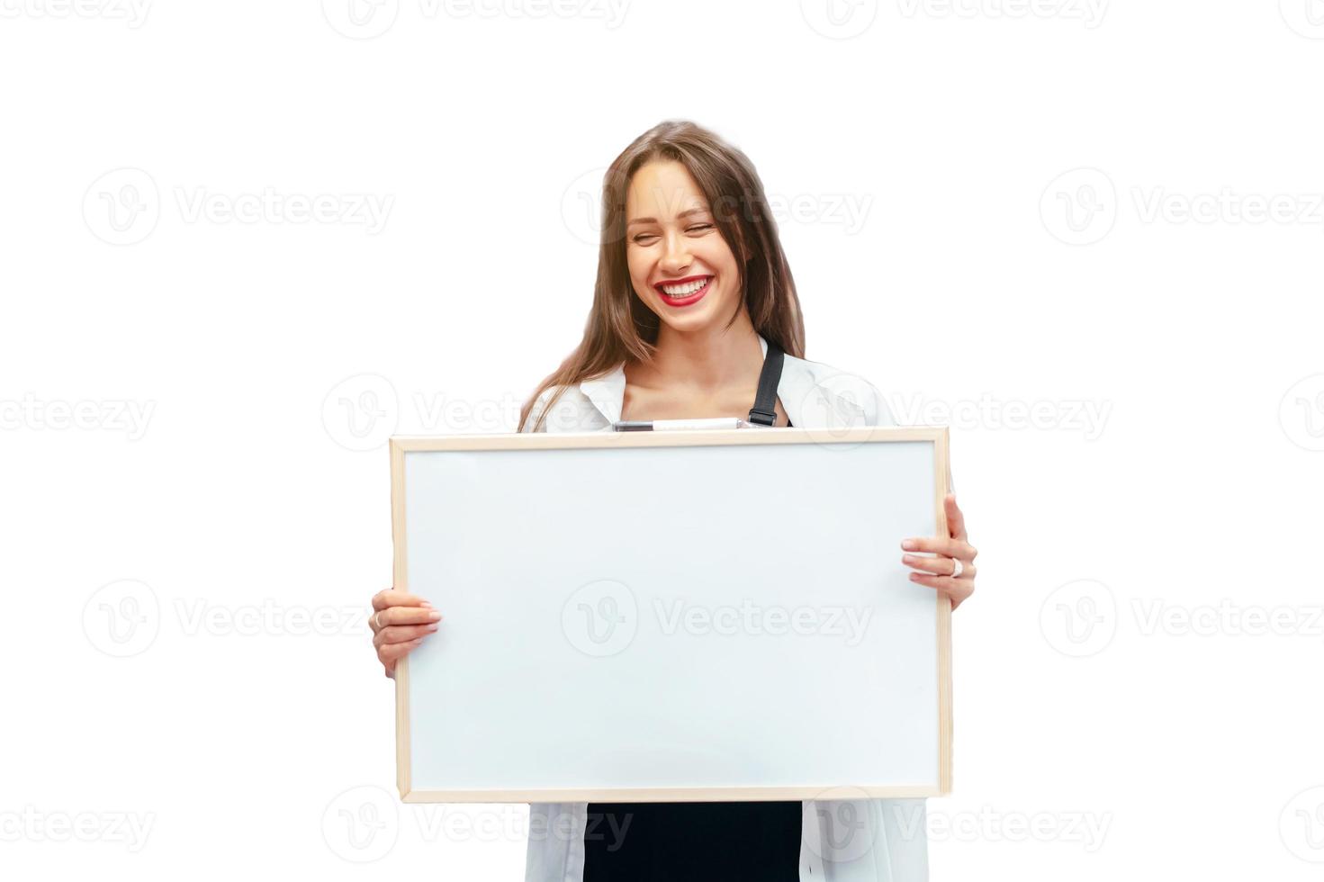 Smiling brunette woman holding white blank board photo