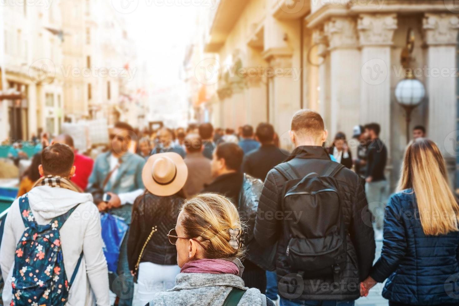 Unrecognizable mass of people walking in the city photo