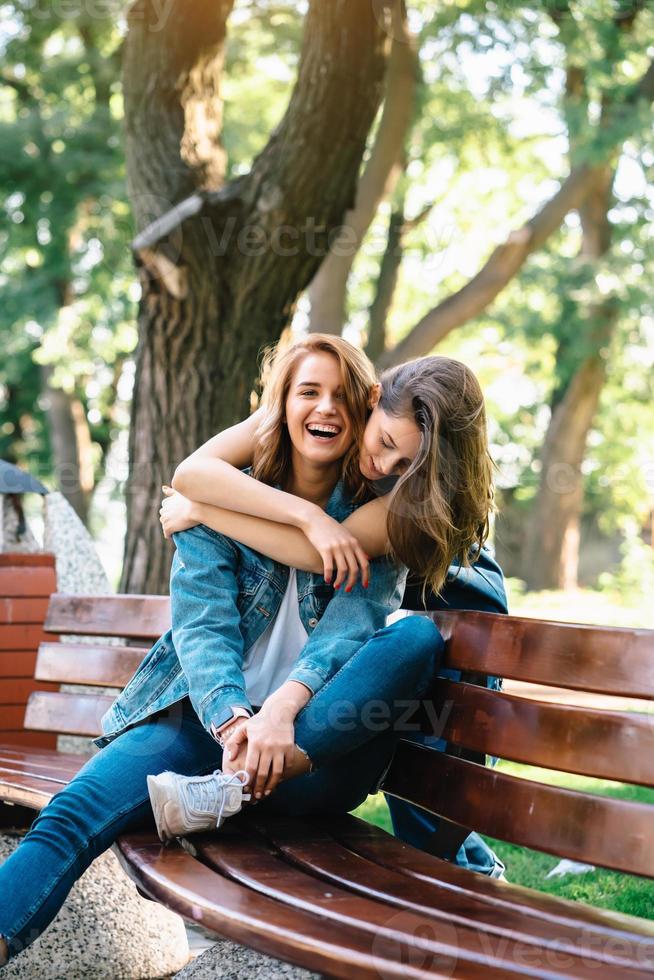 Two beautiful young woman resting on a bench photo