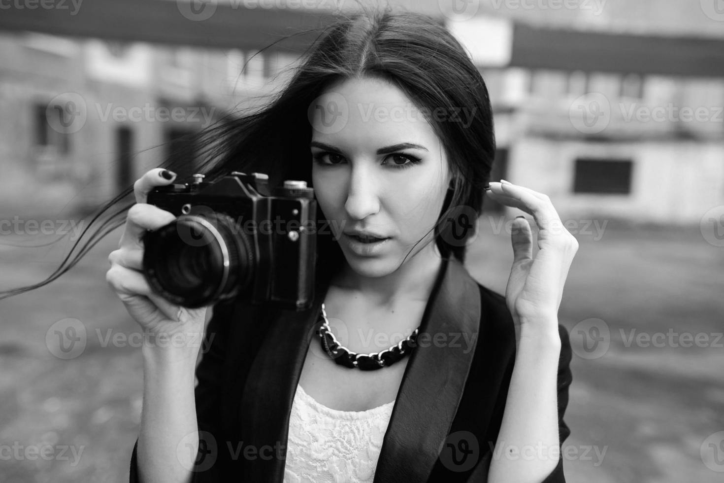 Beautiful female photographer posing with camera photo