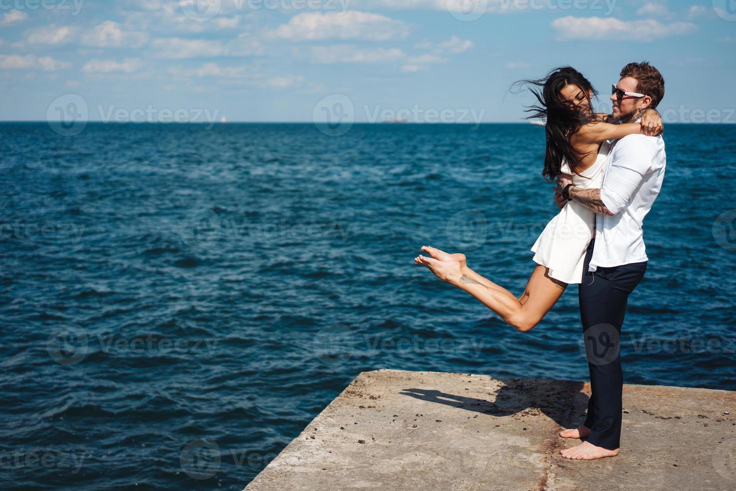 Guy and girl on the sea pier photo