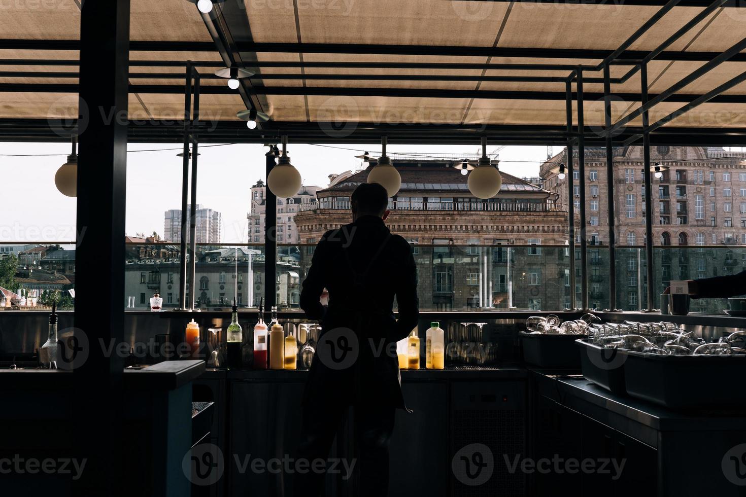 Waiter in a medical protective mask in restaurant photo