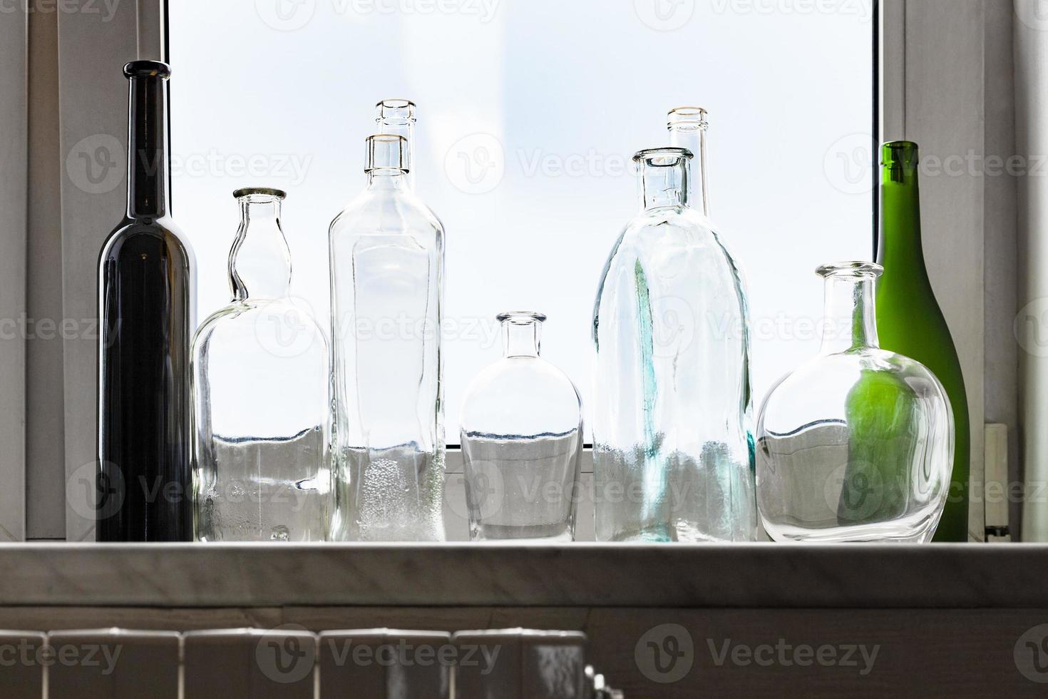 various empty drunk bottles on home windowsill photo