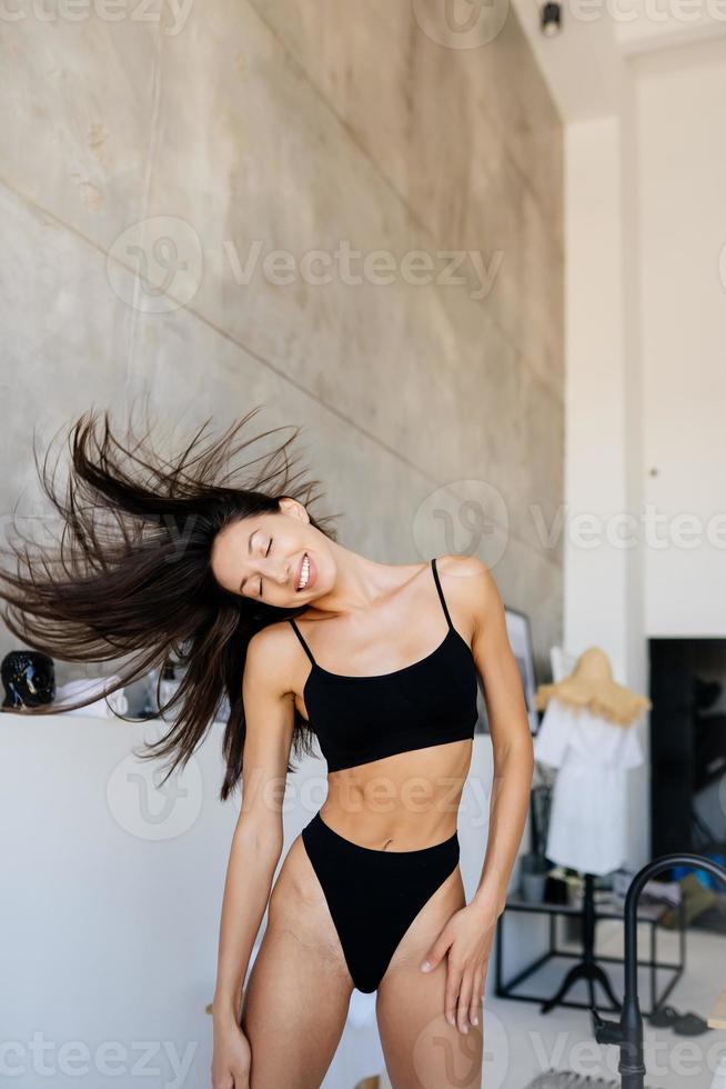 Young attractive girl in black lingerie shaking her head with hair photo