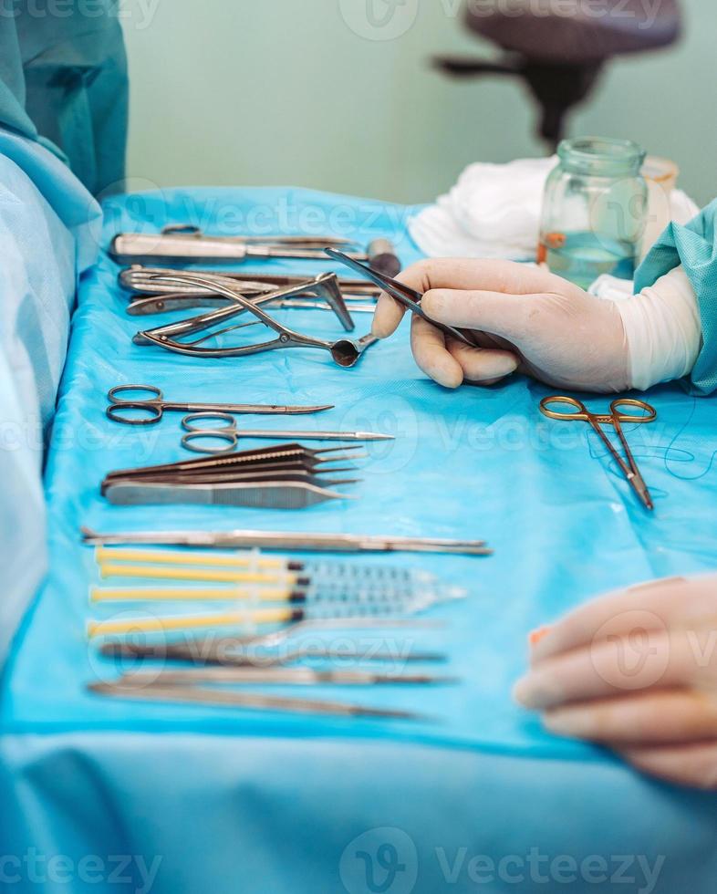 Scrub nurse preparing medical instruments for operation photo