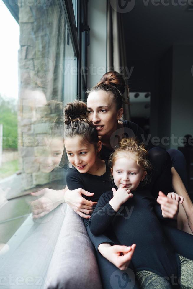 Mom and two daughters together at the window photo