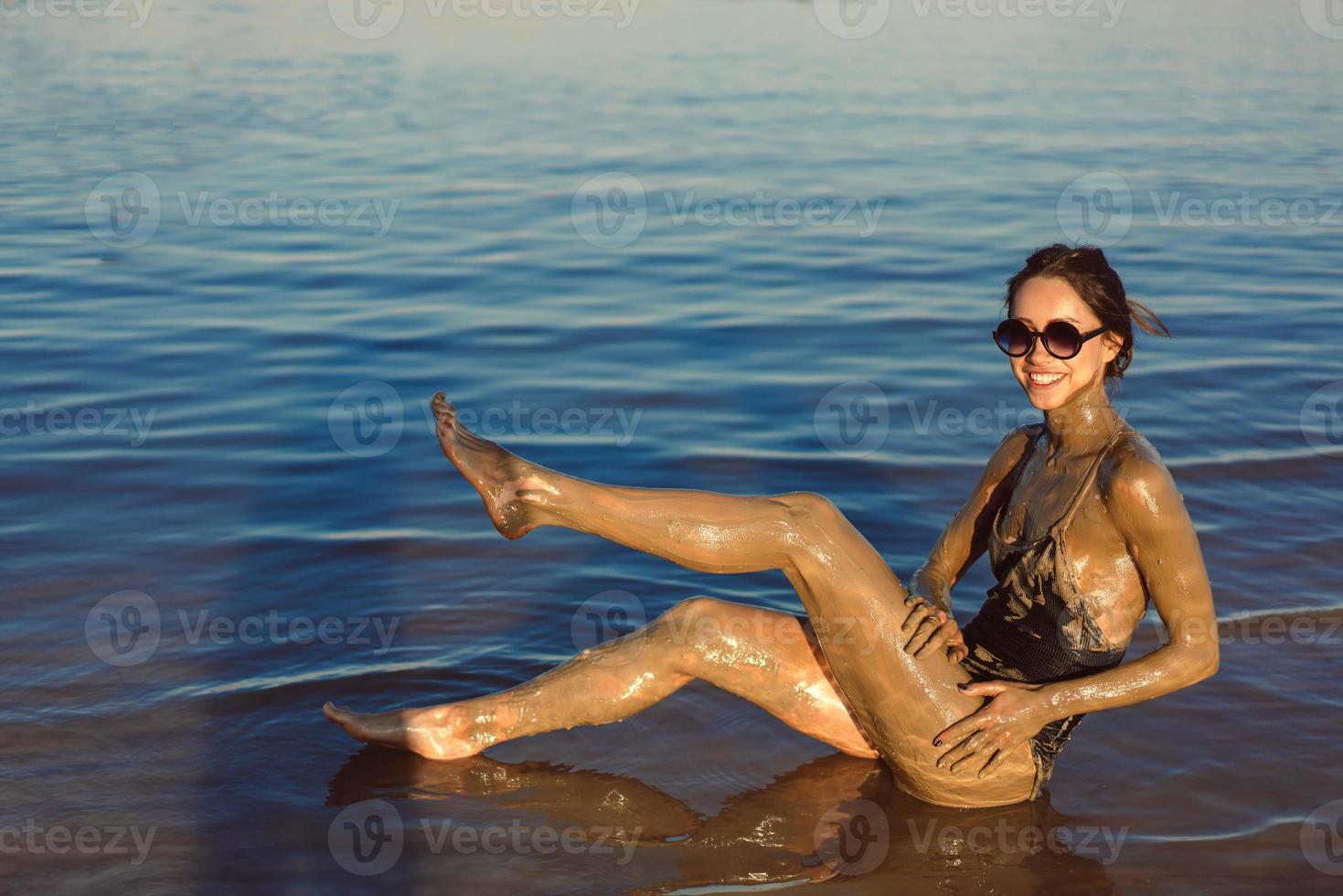 A young woman enjoying the natural mineral mud photo