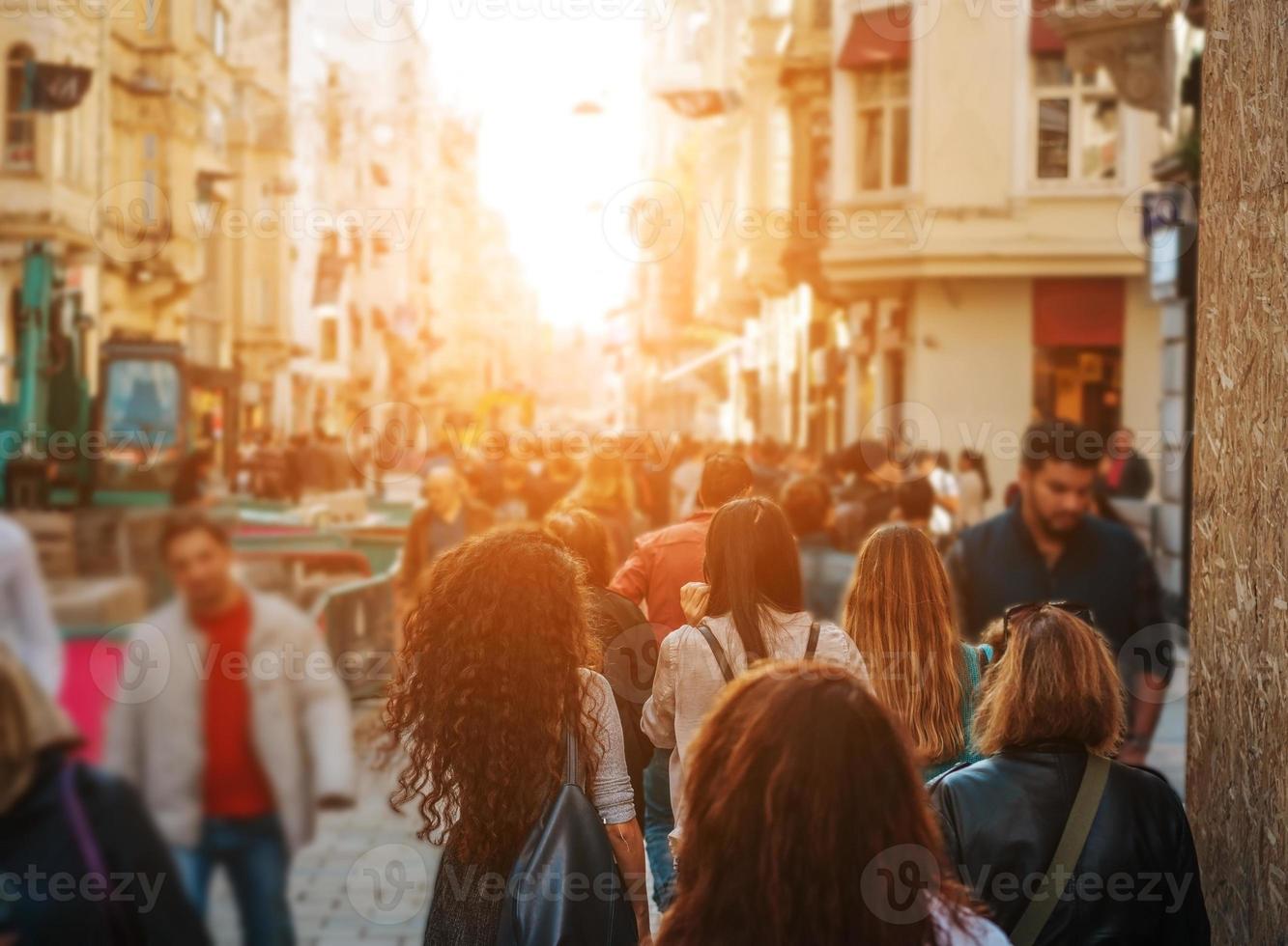 Unrecognizable mass of people walking in the city photo