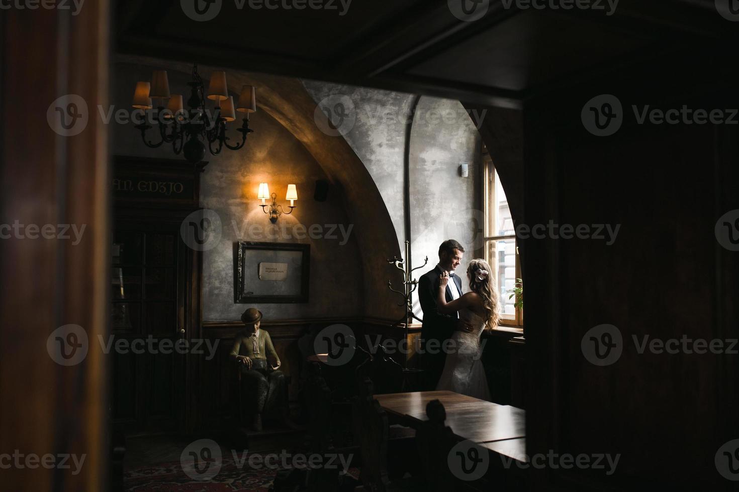 The bride and groom in a cozy house, photo taken with natural light from the window.