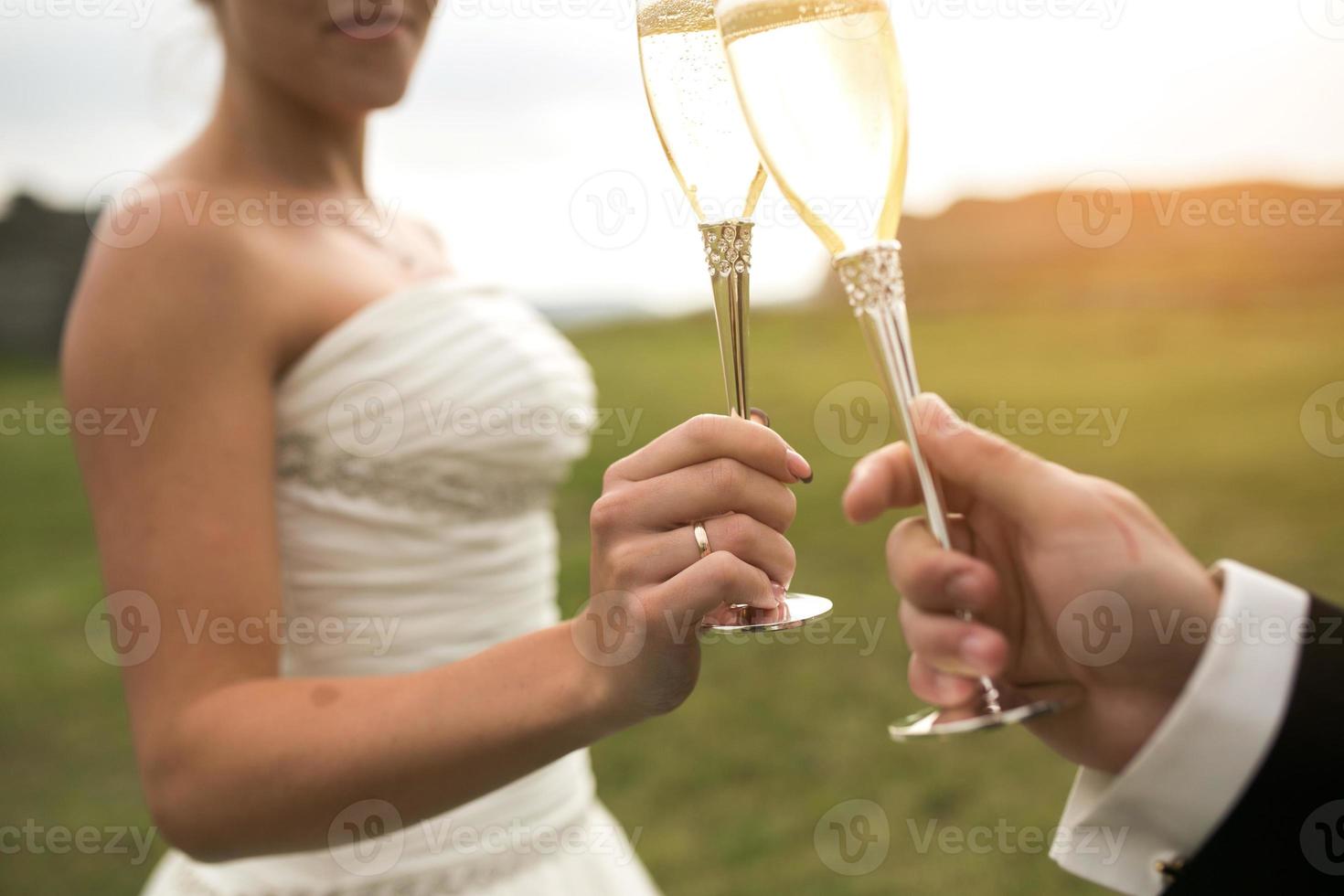 bridal couple clink glasses of champagne photo