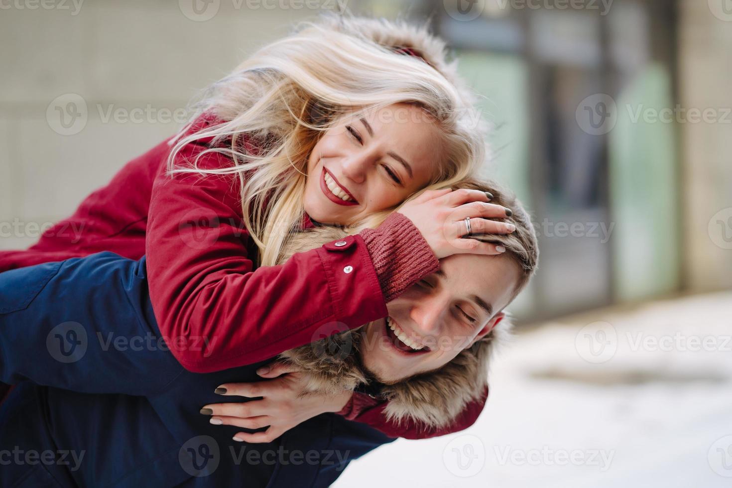 Young handsome guy giving girlfirend piggyback ride photo