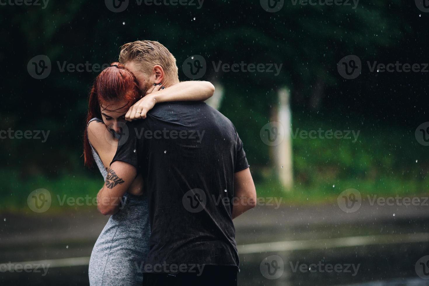 beautiful couple hugging in the rain photo