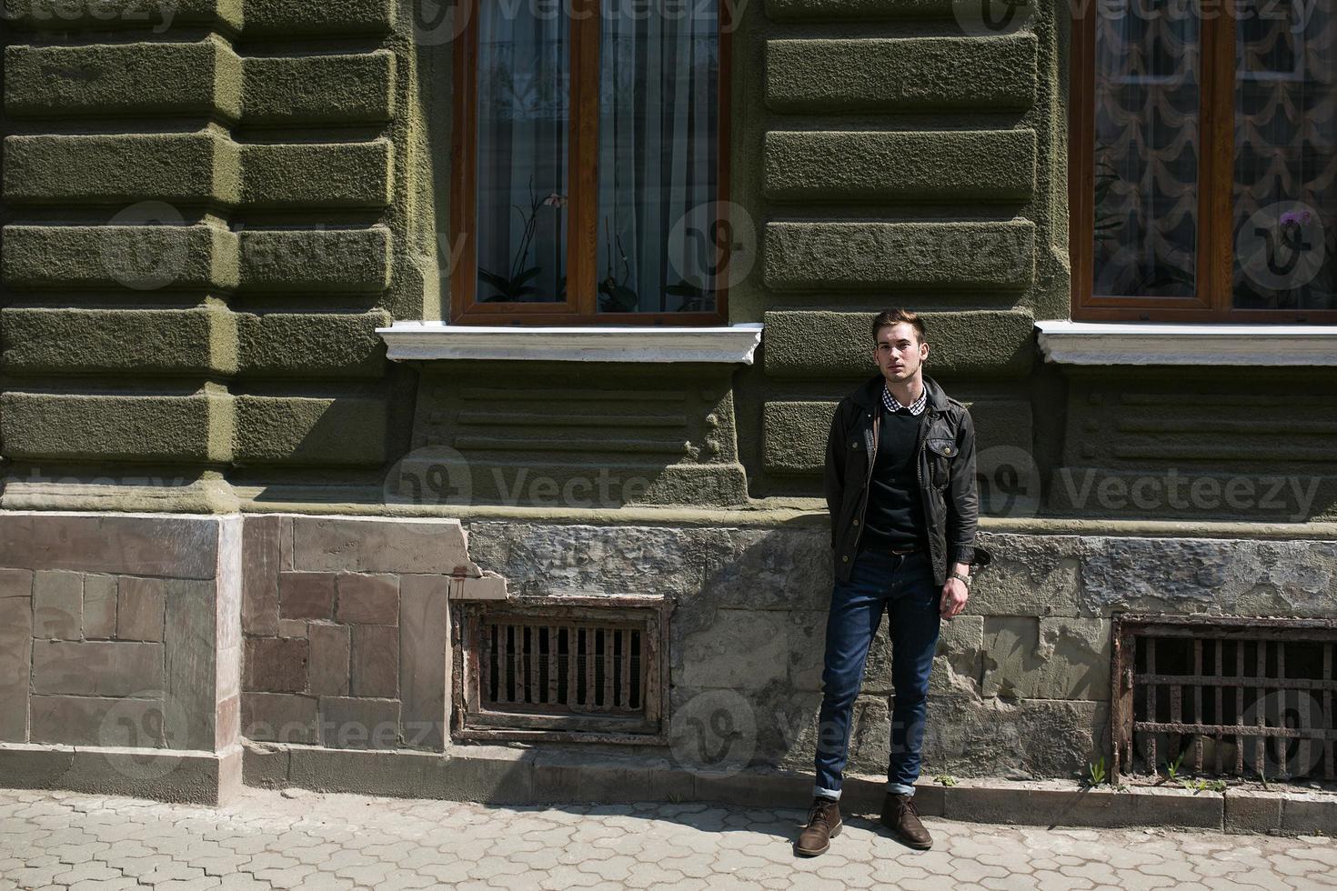 A man dressed in jeans on the background of the old city photo