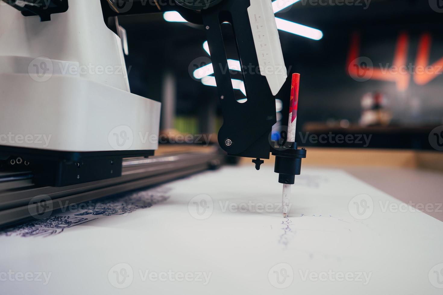 Plotter draws a pen drawing on a sheet of white paper photo