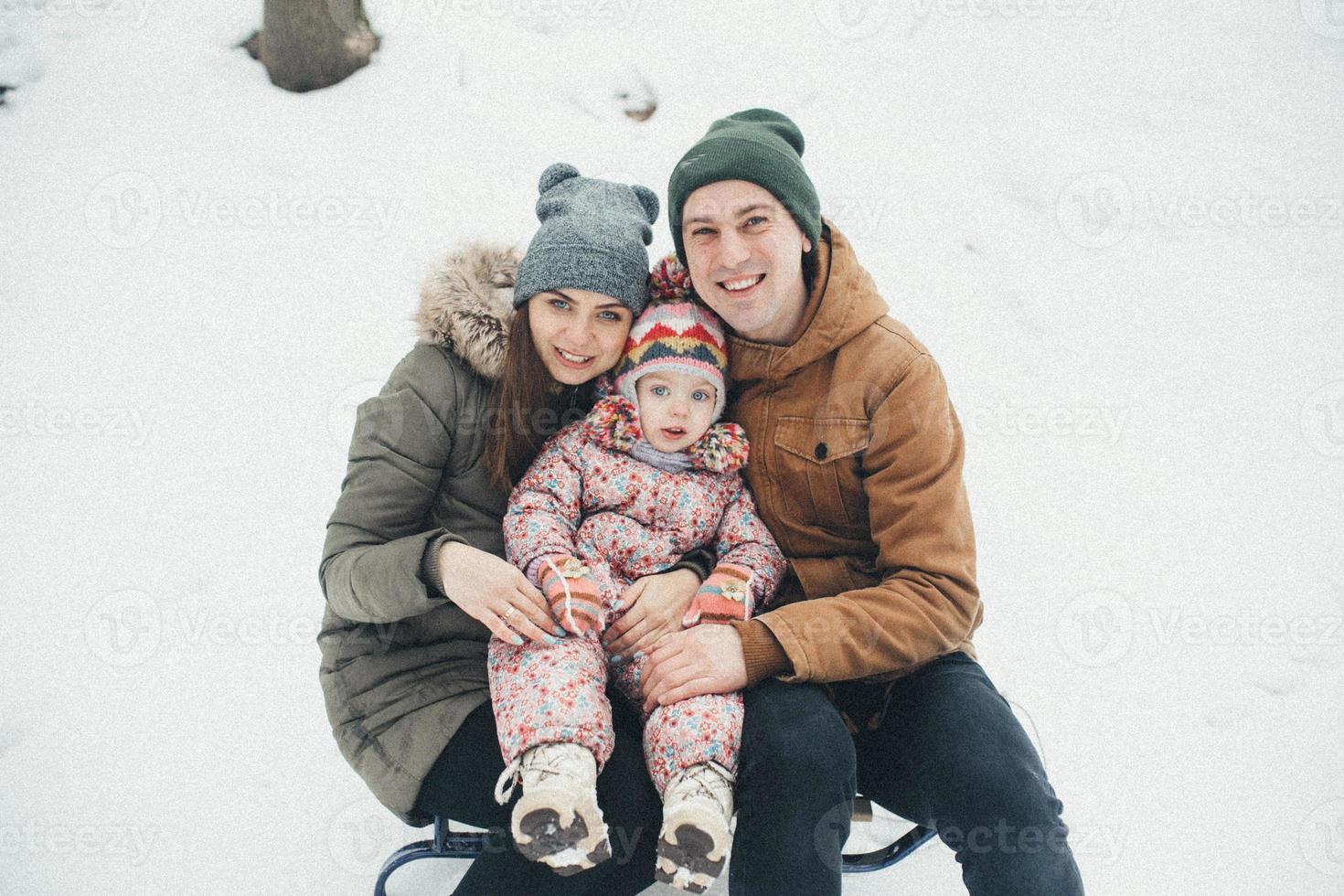 Dad and Mom with a little daughter in the park photo