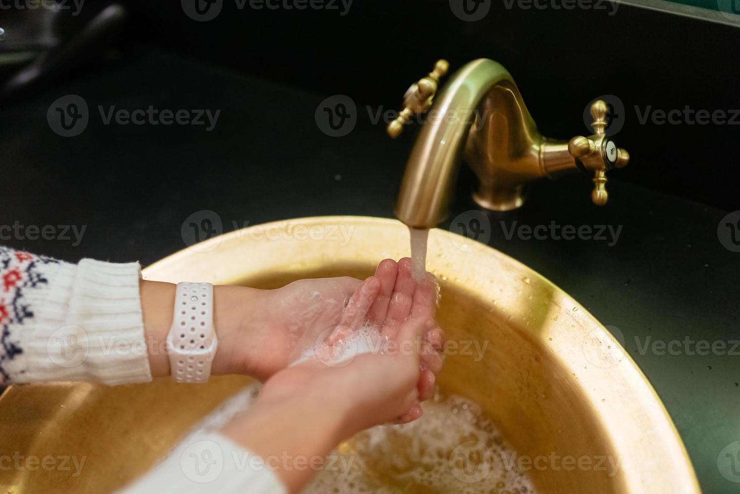 Close up photo of woman washes her hands with soap and water.