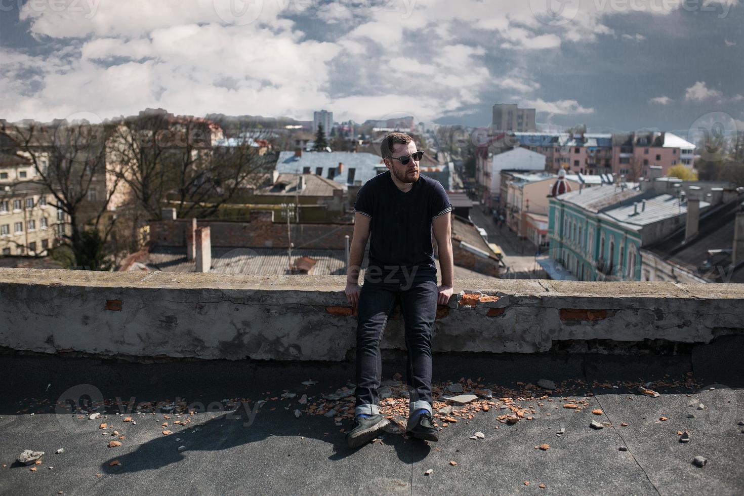 The man in the authentic boots and jeans selvedge on the roof of the building in the old town photo