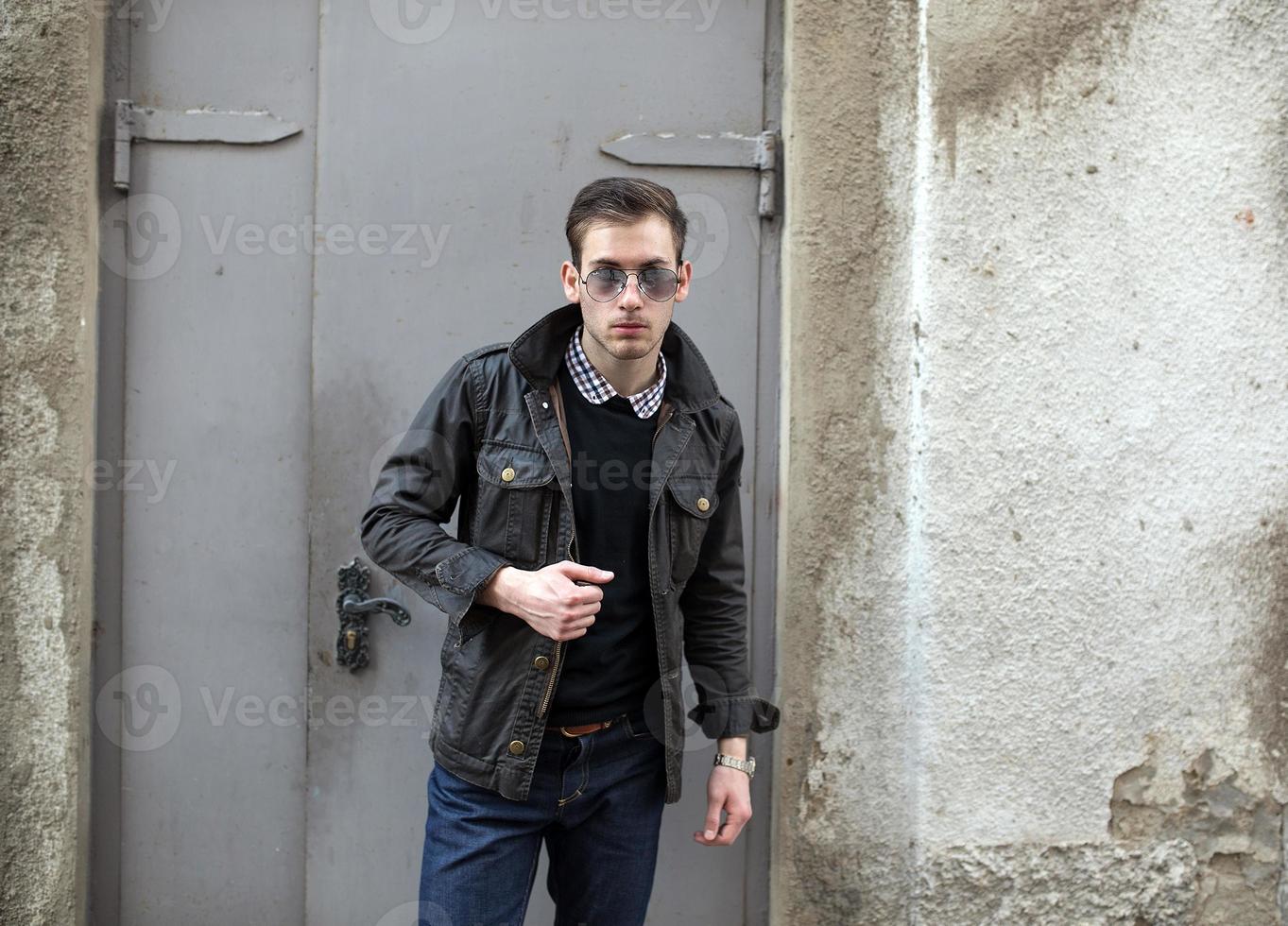 A man dressed in jeans on the background of doors photo