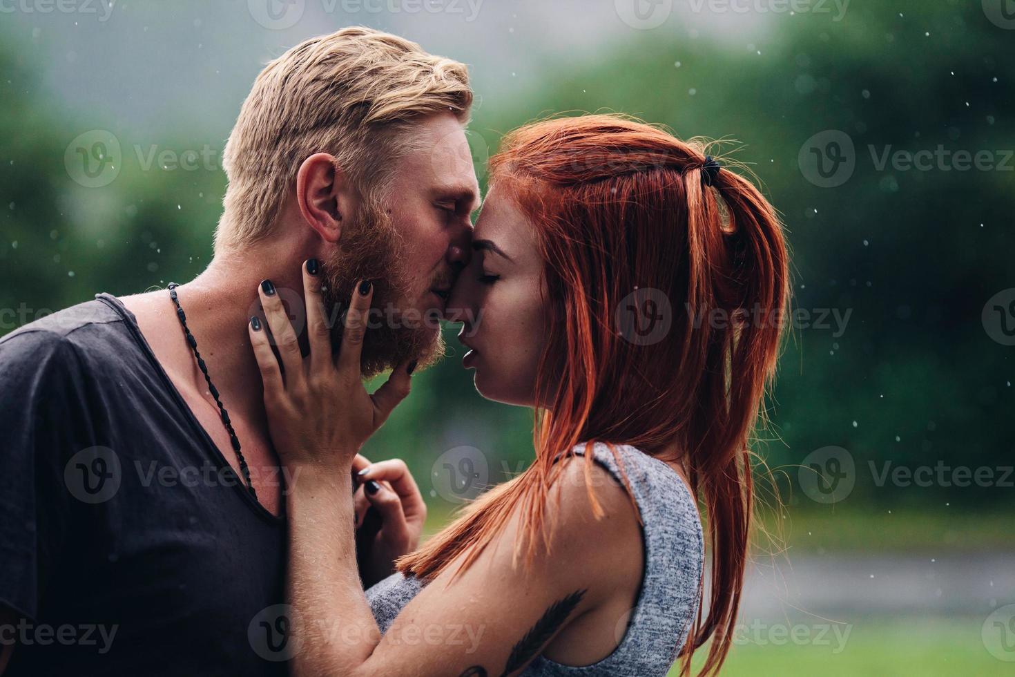 beautiful couple kissing in the rain photo