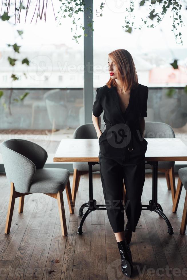 Beautiful woman posing on camera against the background of a large window photo