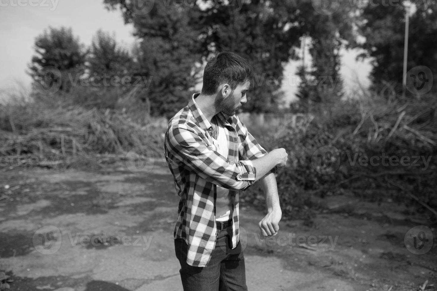 The man in the authentic boots and selvedge jeans  on a the background of branches photo