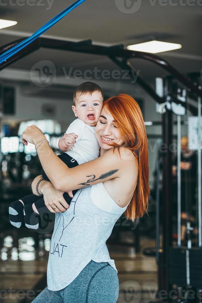 joven madre con su hijo pequeño en el gimnasio foto