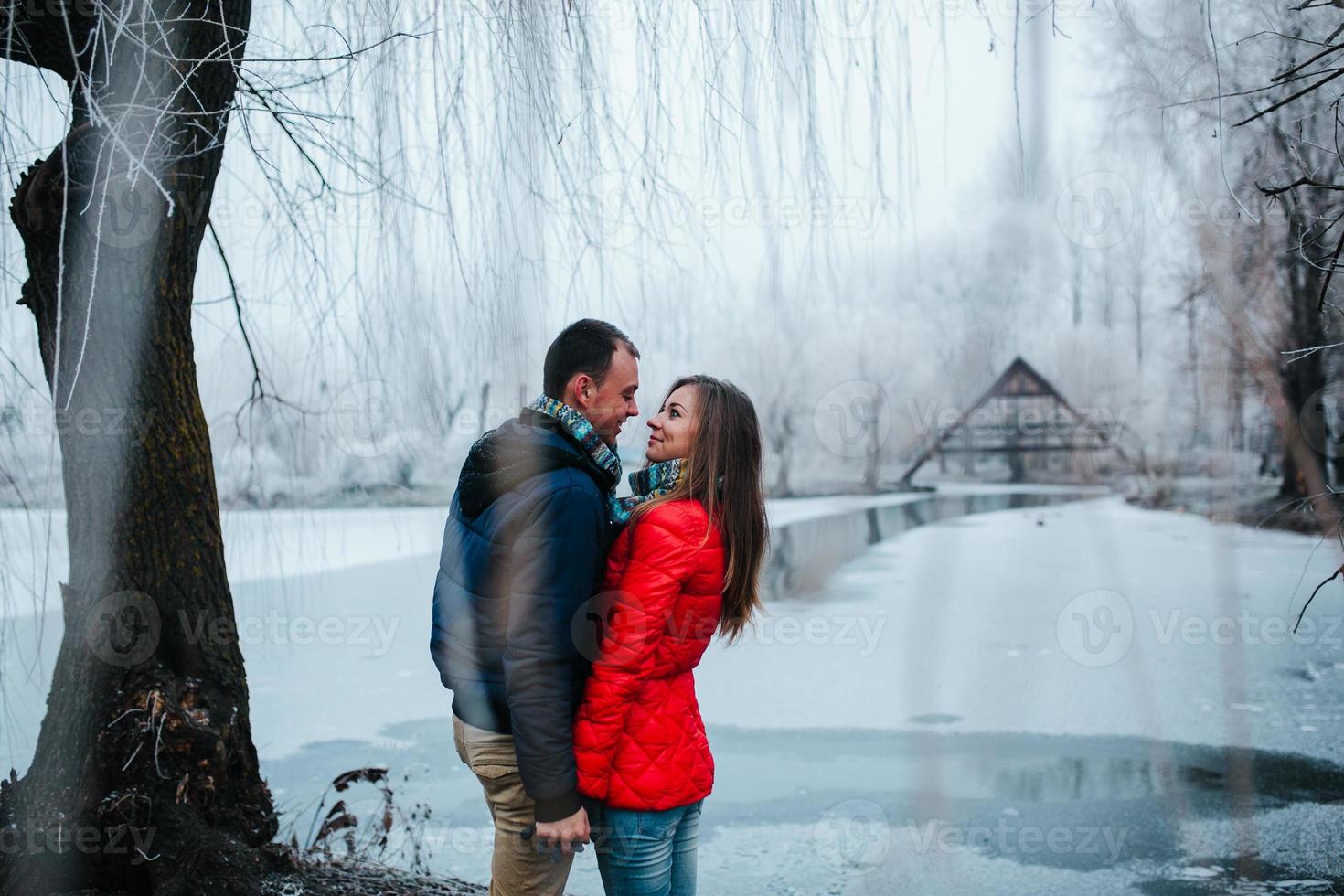 beautiful couple posing near a frozen river photo