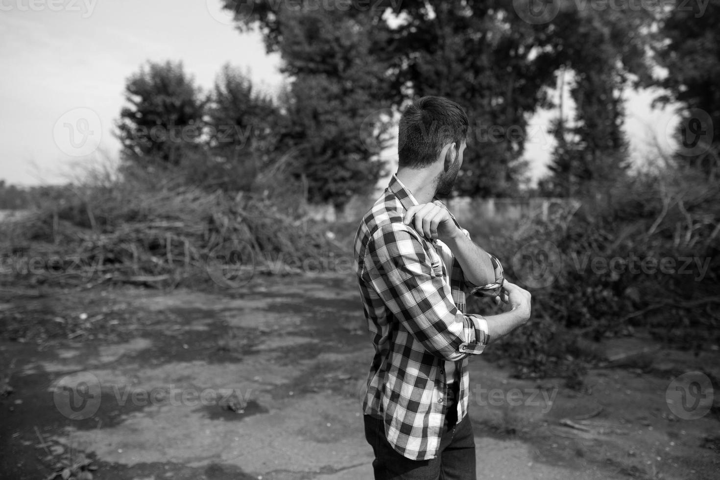 The man in the authentic boots and selvedge jeans  on a the background of branches photo