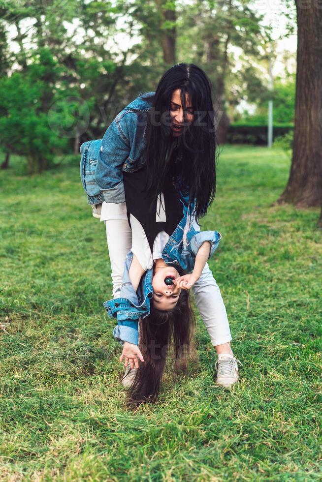 mom and daughter on the lawn have fun photo