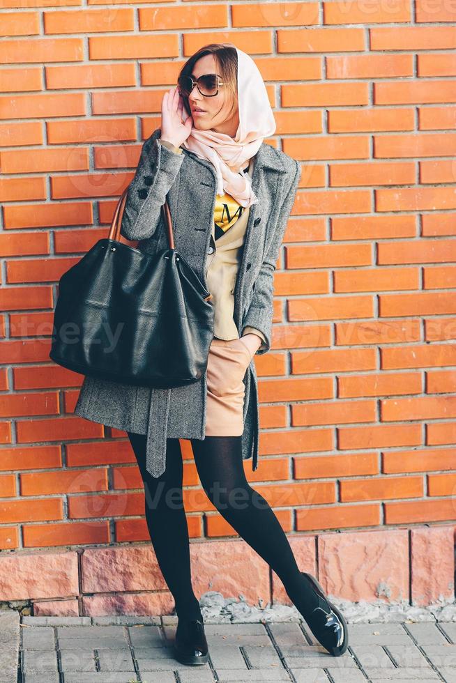 girl posing on a background of red brick wall photo