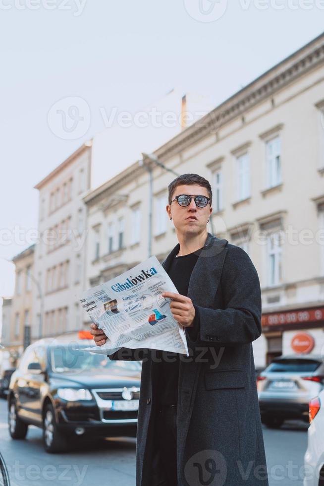 Smart man in sunglasses with paper on street photo