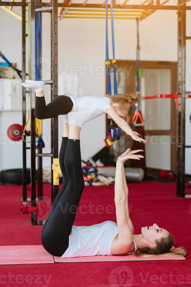 Mom and daughter together perform different exercises photo