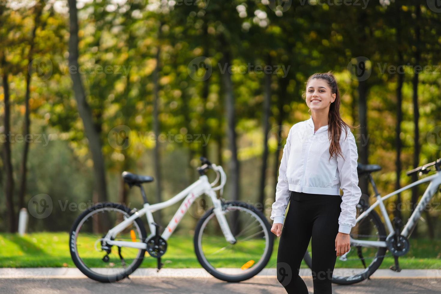 Beautiful girl posing at white bicycle. Walk in nature. photo