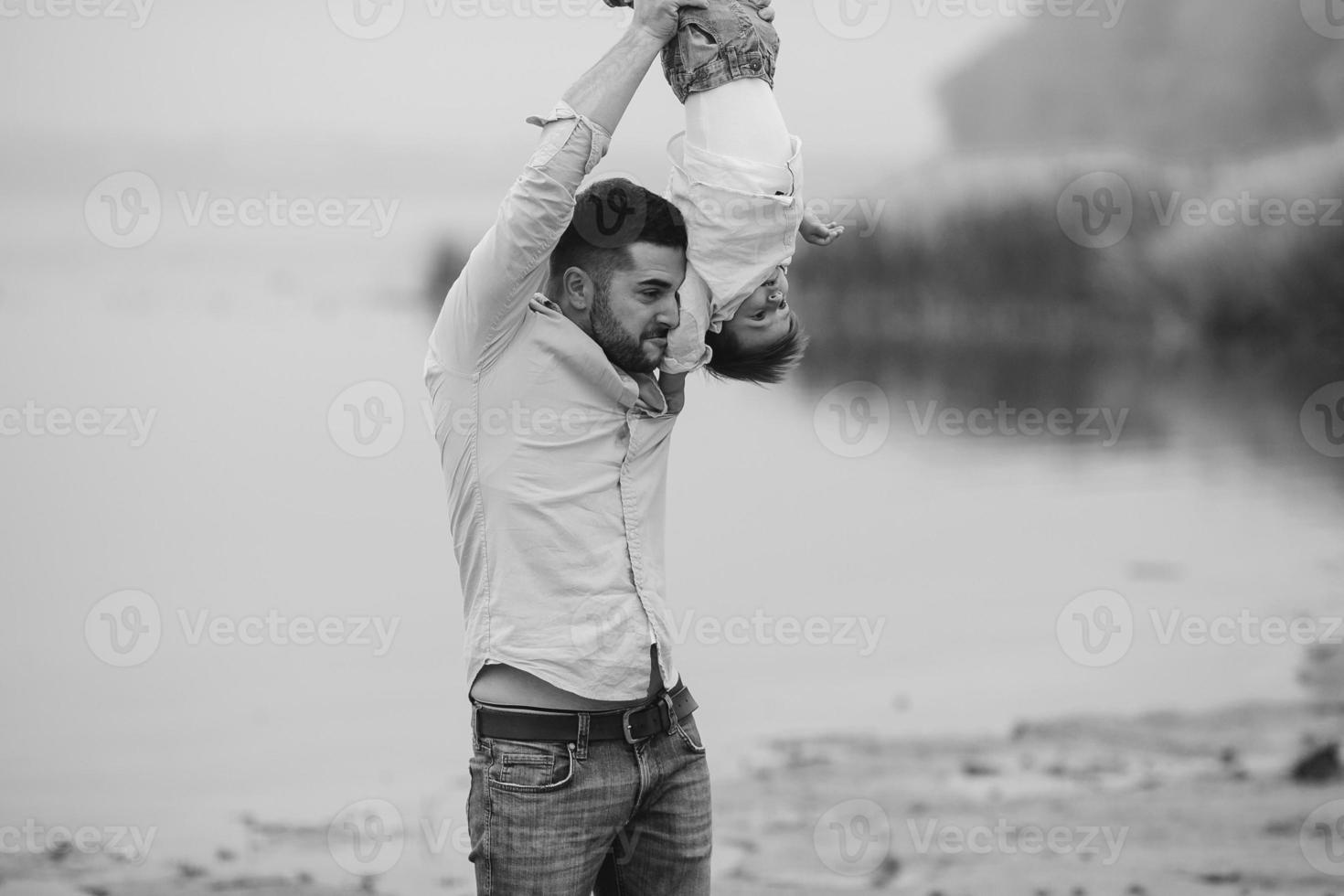 Dad holding infant son by his feet photo
