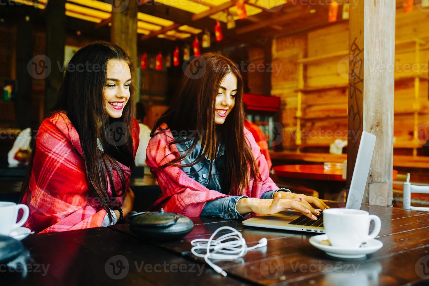 two girls watching something in laptop photo