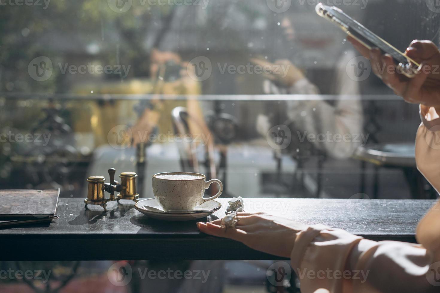 Attractive smiling girl taking photo cup of latte, using smartphone