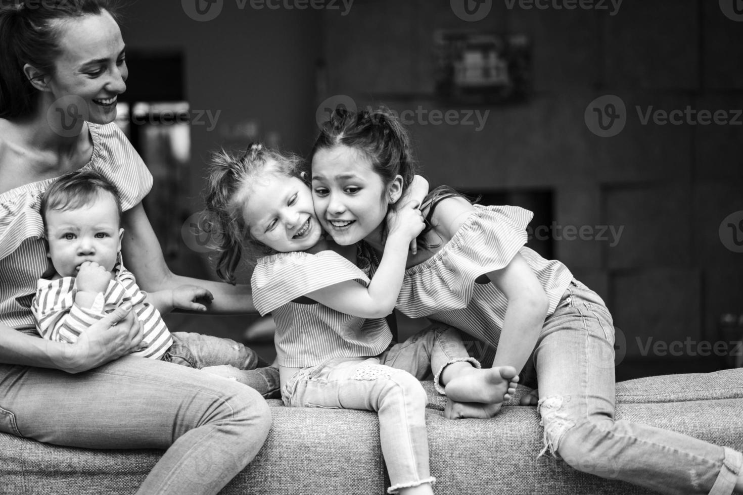 Mom, two daughters and a little son on the couch photo