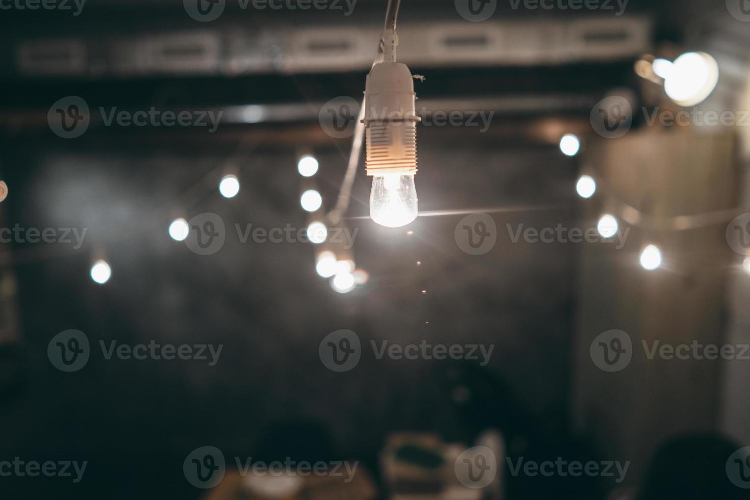 Lamp on garland with lights on background photo